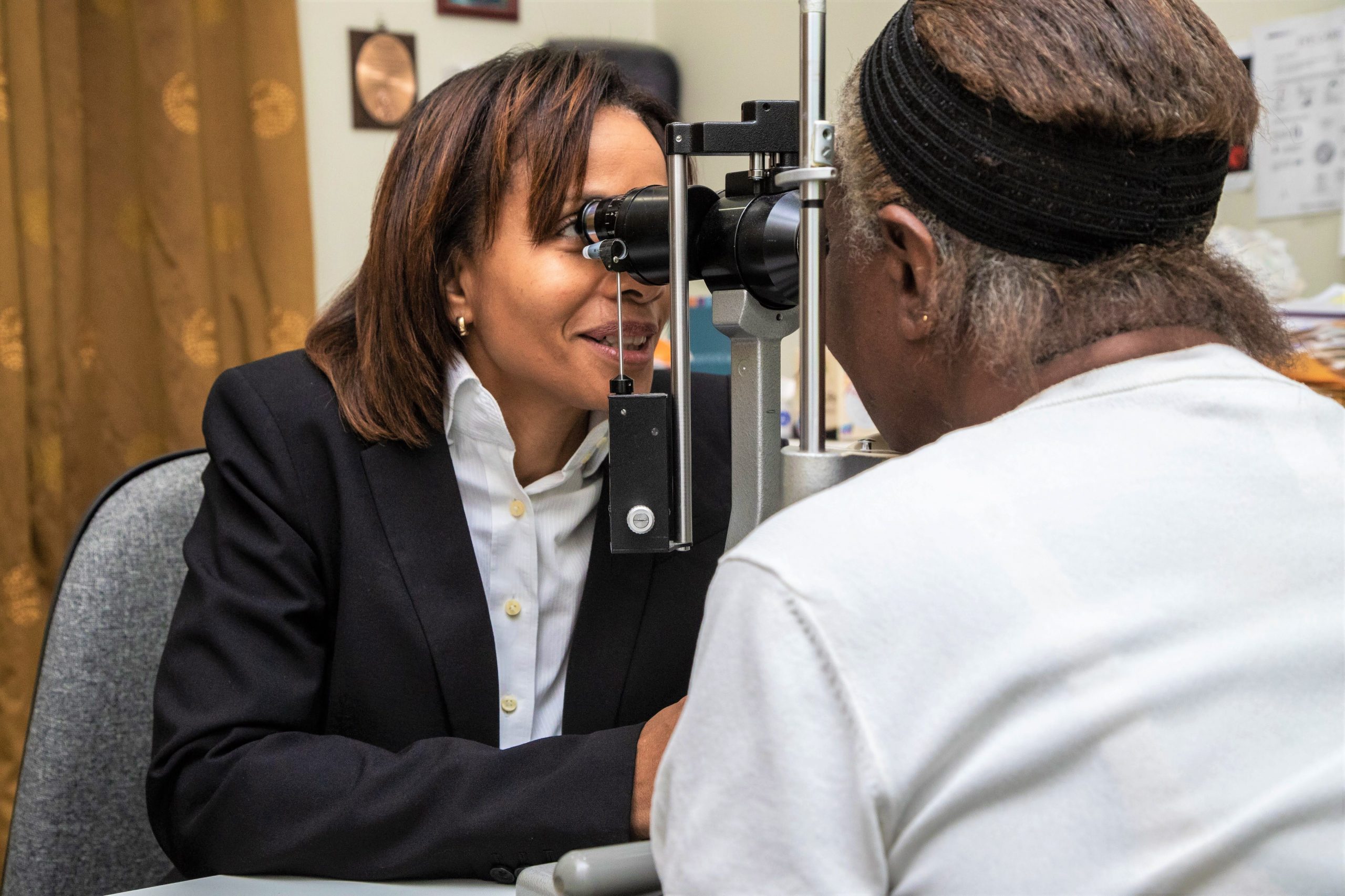 An opthalmologist inspects a patient's eye with a slit lamp