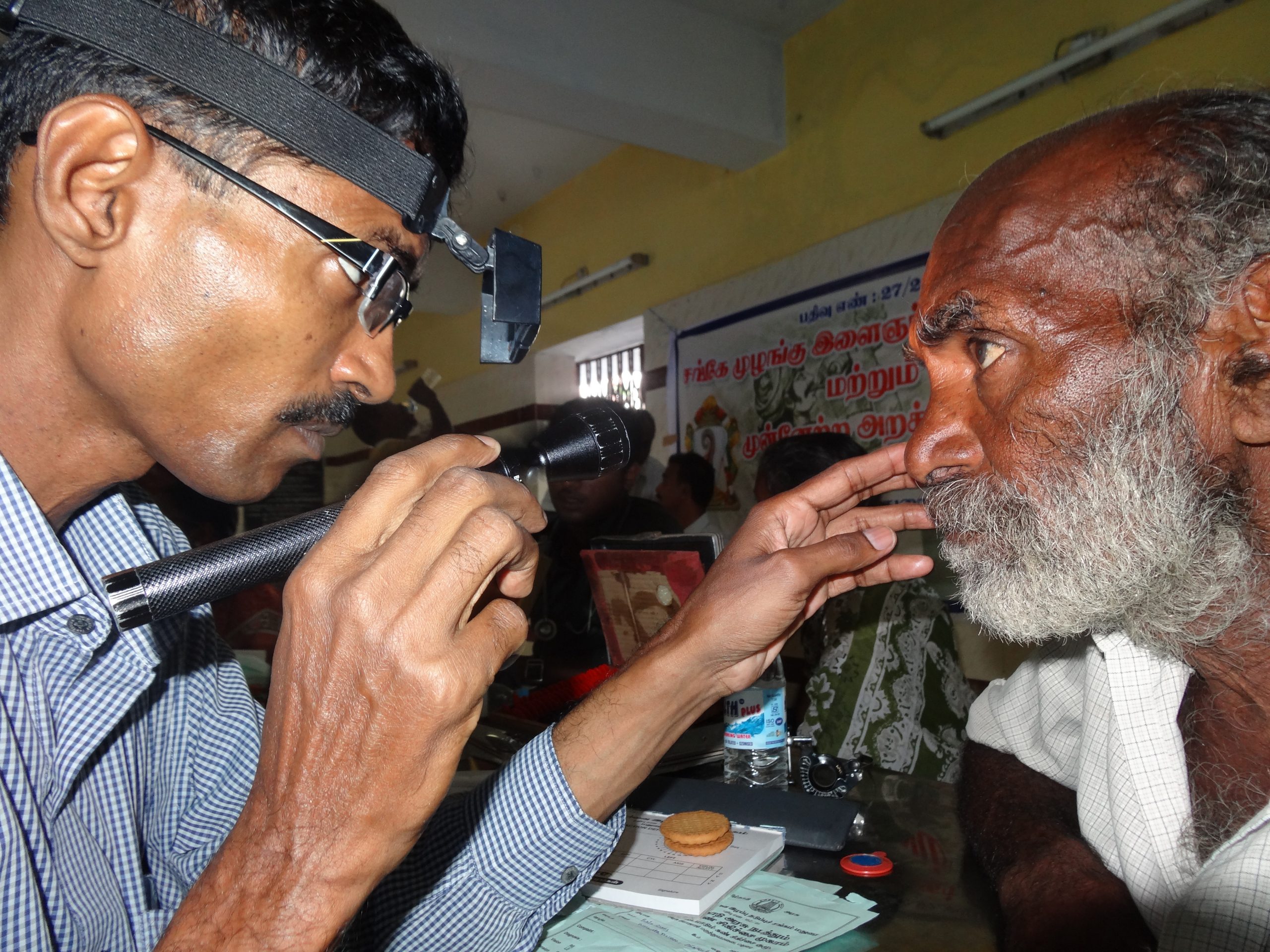 A man is inspected at an eye screening camp in India