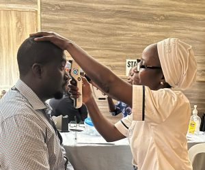 In Nigeria, a health worker uses a portable tonometer on a man