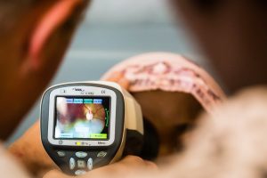 a screen of a retinal camera with a blurred person behind it