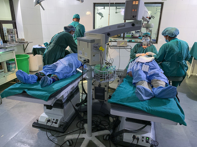 In an operating theatre, two people lie down in scrubs