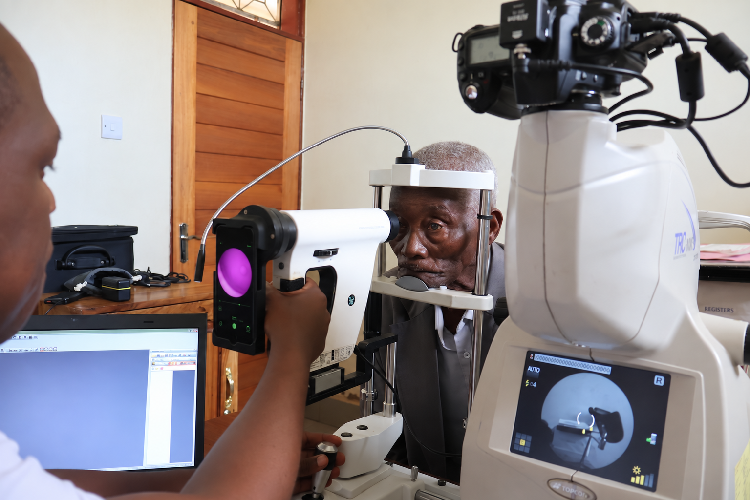 A man receives a retinal scan using a machine including a smart phone
