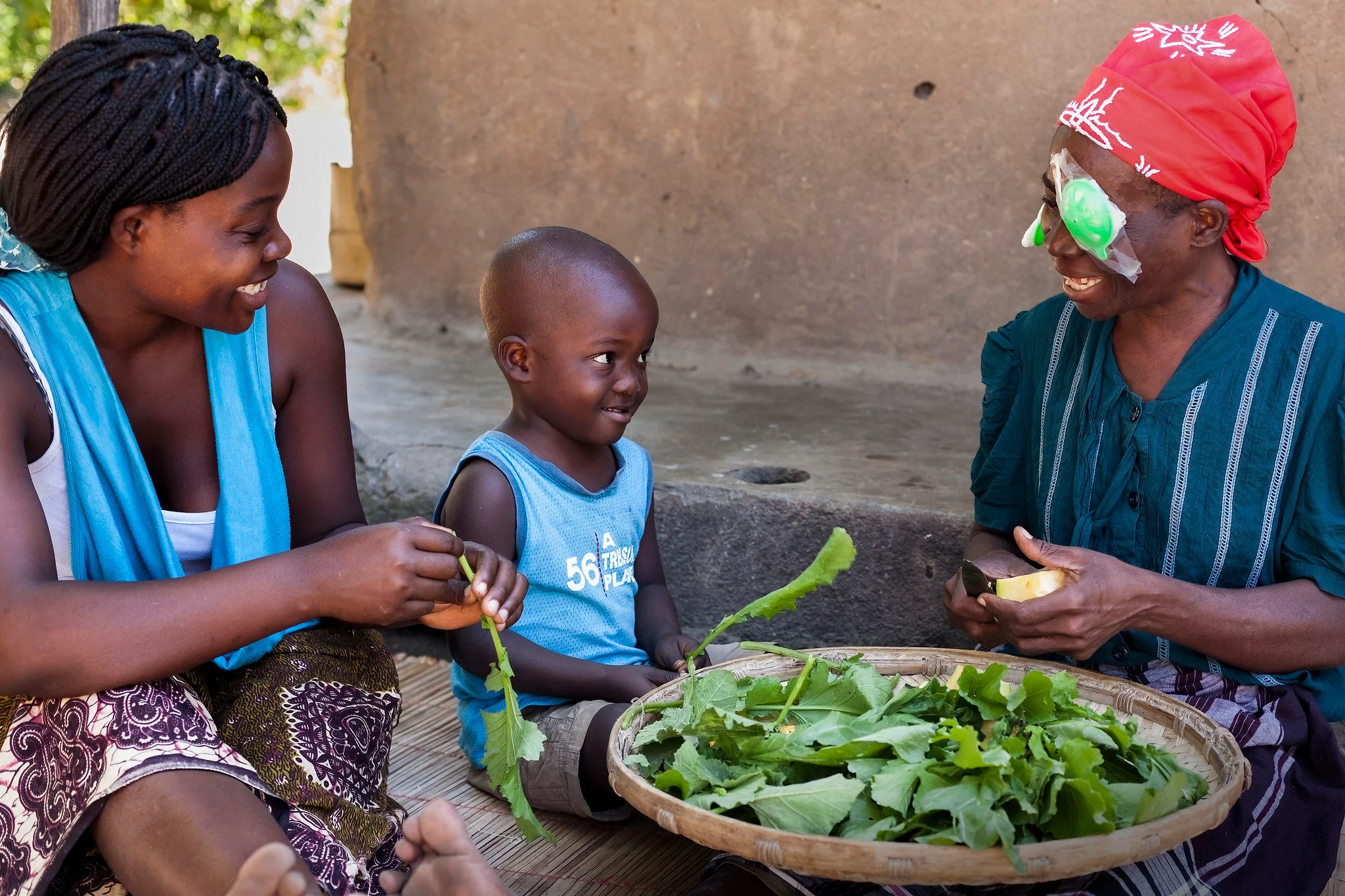a woman with an eye patch after surgery prepares food with a child